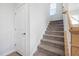 Carpeted stairway with a small window and white walls leading to the upper level of the home at 254 W Odell Ln, Zebulon, NC 27597