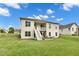 Beautiful backyard view of the house featuring a deck, patio, and lush green lawn on a sunny day at 2613 Beckwith Rd, Apex, NC 27523