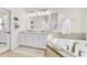 Bright bathroom featuring a soaking tub, double sink vanity, and neutral tile at 2613 Beckwith Rd, Apex, NC 27523