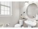 Elegant half bathroom with pedestal sink, modern fixtures, and stylish butterfly accents at 2613 Beckwith Rd, Apex, NC 27523