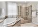 Bright bathroom features a soaking tub and a glass-enclosed shower at 2613 Beckwith Rd, Apex, NC 27523