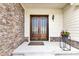 A warm, inviting front porch featuring a wood double door, stone accents, and decorative plants at 2613 Beckwith Rd, Apex, NC 27523