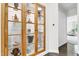 Hallway with hardwood floors and a display cabinet filled with decorative items and artifacts at 2613 Beckwith Rd, Apex, NC 27523