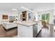 Stylish kitchen island with stainless steel appliances, stone countertops, and a view of the living room with fireplace at 2613 Beckwith Rd, Apex, NC 27523