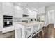 Elegant kitchen with stainless steel appliances, a spacious island with barstool seating, and custom white cabinetry at 2613 Beckwith Rd, Apex, NC 27523