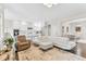 Bright, open-concept living room flows into kitchen with white cabinetry and features modern furnishings and hardwood floors at 2613 Beckwith Rd, Apex, NC 27523