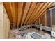Unfinished attic area, with exposed wooden beams and plentiful insulation at 2613 Hiking Trl, Raleigh, NC 27615