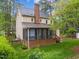 Back exterior showcasing the screened in porch, large chimney and spacious backyard, perfect for outdoor activities at 2613 Hiking Trl, Raleigh, NC 27615