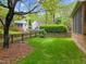 Serene backyard setting with a privacy fence, mature landscaping, and vibrant green grass at 2613 Hiking Trl, Raleigh, NC 27615