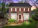 Charming brick home with red shutters, bay windows, a manicured lawn, and an American flag at 2613 Hiking Trl, Raleigh, NC 27615