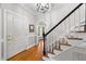 Inviting foyer featuring hardwood floors, stairs with carpet runner, and a decorative light fixture at 2613 Hiking Trl, Raleigh, NC 27615