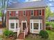 Close up of the front exterior with brick facade, bay windows, and a welcoming entryway with an American flag at 2613 Hiking Trl, Raleigh, NC 27615