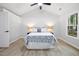 Bright bedroom with a ceiling fan, large window, and light wood flooring at 2709 Hidden Hollow Dr, Durham, NC 27703
