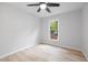 Bright, empty bedroom with ceiling fan, light wood floors, and a view of the backyard at 2709 Hidden Hollow Dr, Durham, NC 27703