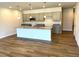 Open-concept kitchen featuring a large island, stainless microwave and modern pendant lighting at 288 Olivia Crossing Ct # 10, Four Oaks, NC 27524