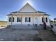 New construction home featuring white siding, black shutters, and a welcoming front porch with exposed pillars at 2895 Bakers Chapel Rd, Smithfield, NC 27577
