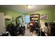 Cluttered green room with exercise equipment, shelves, and a desk at 300 E Vance St, Zebulon, NC 27597