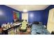 Blue bedroom with a gaming chair, monitor, desk, and a bed at 300 E Vance St, Zebulon, NC 27597