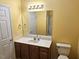 Bathroom features single sink vanity, large mirror, and toilet with yellow walls at 3015 Winston Dr # 111, Burlington, NC 27215
