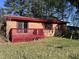 Exterior of a brick home with a red metal roof and a matching deck at 327 Holland Dr Rd, Smithfield, NC 27577