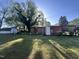 Exterior of a brick home with a red metal roof with a large yard and shed at 327 Holland Dr Rd, Smithfield, NC 27577