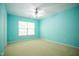 Bright bedroom with light green walls, neutral carpet, and a ceiling fan at 3303 Silver Star Dr, Durham, NC 27713