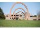 Three curved art sculptures on a grassy field, set against a modern building facade at 3308 Churchill Rd, Raleigh, NC 27607
