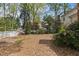 Spacious backyard featuring mature trees, lush landscaping, and privacy fence, perfect for outdoor enjoyment and entertaining at 3308 Churchill Rd, Raleigh, NC 27607