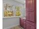 Bathroom features pink cabinetry with granite counters, a window, and neutral flooring at 3308 Churchill Rd, Raleigh, NC 27607