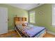 Bedroom features hardwood floors, closet, and a bed with a colorful quilt and two windows at 3308 Churchill Rd, Raleigh, NC 27607