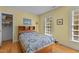 Bedroom with hardwood floors, two windows, closet, and bed with blue patterned quilt at 3308 Churchill Rd, Raleigh, NC 27607