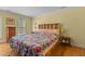 Bedroom features a colorful quilt, a built-in headboard with shelving and hardwood floors at 3308 Churchill Rd, Raleigh, NC 27607