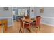 Dining area showcasing wood floors, seating for four, and a partial view of a bright kitchen at 3308 Churchill Rd, Raleigh, NC 27607