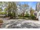 Large driveway with mature trees, landscaping, and brick-lined perimeter; a welcoming entrance to the property at 3308 Churchill Rd, Raleigh, NC 27607