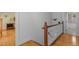 Bright hallway features hardwood floors, white railing, and access to a tiled bathroom at 3308 Churchill Rd, Raleigh, NC 27607
