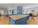 Bright kitchen island and partial view of dining area, hardwood floors, and blue cabinets at 3308 Churchill Rd, Raleigh, NC 27607
