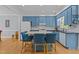Well-lit kitchen featuring blue cabinets, a spacious island with seating, and hardwood flooring at 3308 Churchill Rd, Raleigh, NC 27607