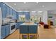 Spacious kitchen featuring blue cabinets, an island with seating, and stainless steel appliances at 3308 Churchill Rd, Raleigh, NC 27607