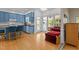 Open kitchen and sunroom area with breakfast bar seating, blue cabinetry and hardwood floors at 3308 Churchill Rd, Raleigh, NC 27607
