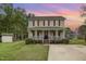 Charming home featuring a cozy front porch, well-maintained landscaping, and a welcoming American flag at 34 Stuart Dr, Benson, NC 27504