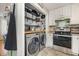 Functional laundry setup with shelving and stainless steel appliances next to the kitchen at 34 Stuart Dr, Benson, NC 27504