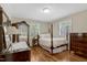 Cozy bedroom with hardwood floors, a comfortable bed, and bright natural light at 3508 Cole Mill Rd, Durham, NC 27712