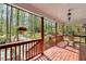 Inviting porch with wood floors, rustic railings, and a peaceful view of the wooded landscape at 3508 Cole Mill Rd, Durham, NC 27712