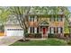 Charming two-story brick home with a well-manicured lawn, red front door, and attached two-car garage at 3517 Boren Ct, Raleigh, NC 27616