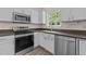 Well-lit kitchen featuring stainless steel appliances, white cabinetry, and a window view at 3517 Boren Ct, Raleigh, NC 27616