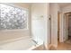Bright bathroom featuring a soaking tub with a decorative window and a separate glass-enclosed shower at 360 Callandale Ln, Durham, NC 27703