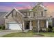 Charming two-story brick home with a two car garage and well-manicured lawn at 360 Callandale Ln, Durham, NC 27703