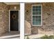Inviting front porch of a brick home with decorative door wreath and window at 360 Callandale Ln, Durham, NC 27703