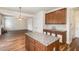 Open kitchen view showcases island with granite countertops and wood cabinets at 360 Callandale Ln, Durham, NC 27703