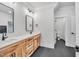 Bathroom featuring double sinks with wood cabinetry, white countertops, and sleek black fixtures at 3832 Noremac Dr, Raleigh, NC 27612